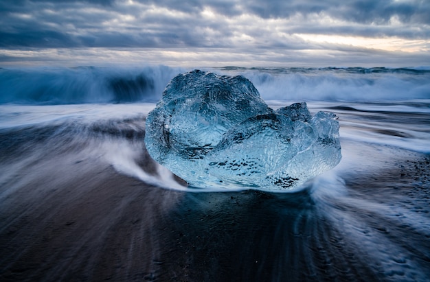 Closeup shot of a glacier lagoon in Iceland with a wavy sea on the background