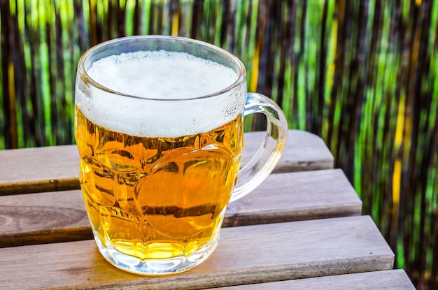 Free photo closeup shot of a glass of cold beer on a wooden surface