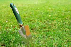 Free photo closeup shot of a hand trowel on the green grass