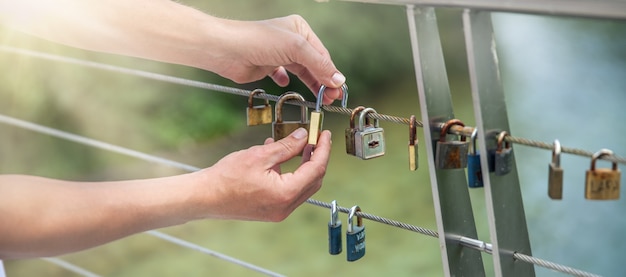 Free photo closeup shot of hands hanging locks on a rope - concept of love