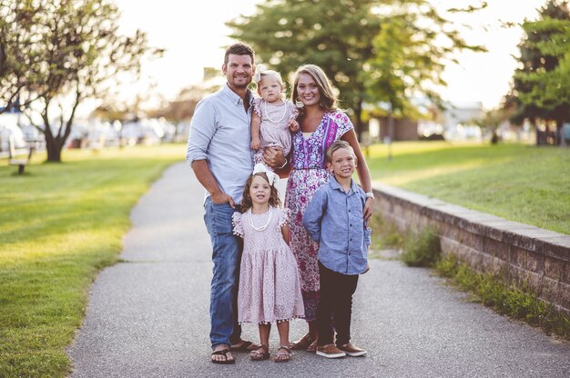 Closeup shot of a happy family standing on the grass near the harbor - family concept