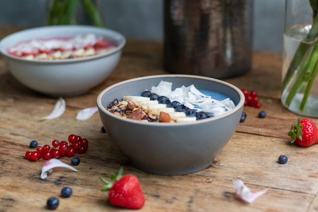 Closeup shot of healthy smoothie bowls with fruits and granola