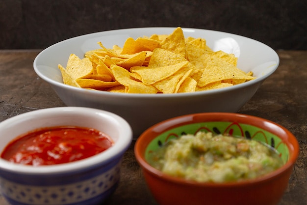 Closeup shot of ketchup, vegetable salad and chips in bowls