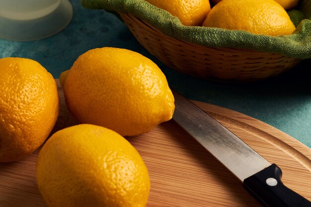 Closeup shot of lemons on a wooden cutting board and in a basket