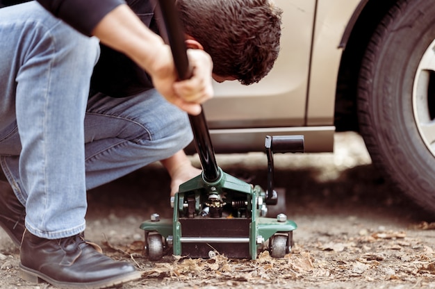 Free photo closeup shot of a man repairing a car with a tool