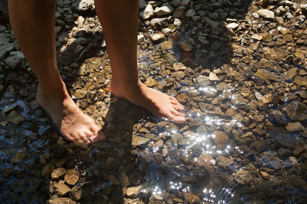 Free Photo closeup shot of a man's foot in river water filled with small stones