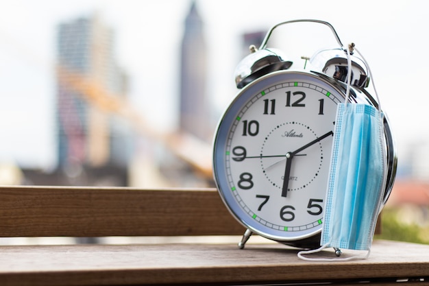 Free photo closeup shot a metallic alarm with a medical mask hanging on it