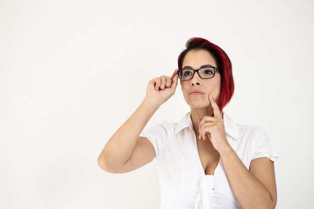 Closeup shot of a middle-aged and red-haired female isolated on a white wall