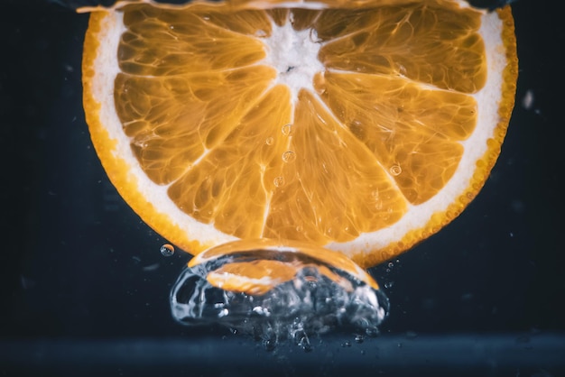 Free Photo closeup shot of an orange slice splashing in water