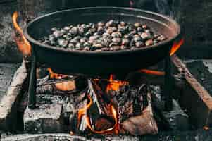 Free photo closeup shot of a pan of chestnuts roasting on the fire