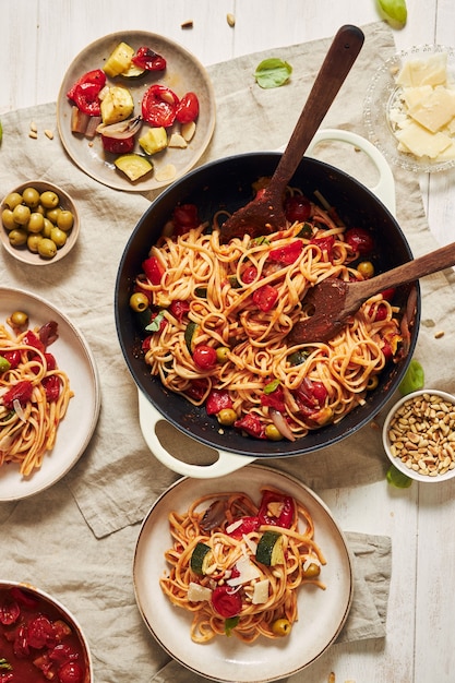 Free photo closeup shot of pasta with vegetables and ingredients on a white table