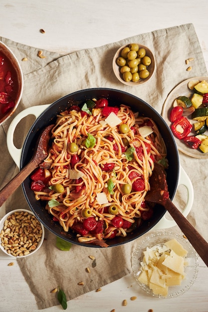 Free photo closeup shot of pasta with vegetables and ingredients on a white table