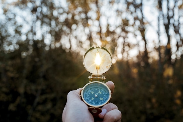 Free photo closeup shot of a person holding a compass with the sun shining through the hole