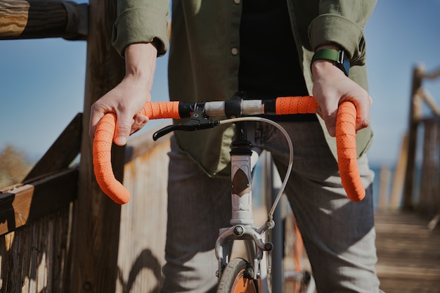 Free photo closeup shot of a person holding an orange bike handlebar