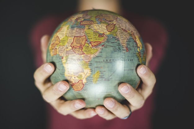 Free Photo closeup shot of a person holding a small globe with two hands