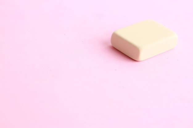 Free Photo closeup shot of a piece of butter on a light pink background