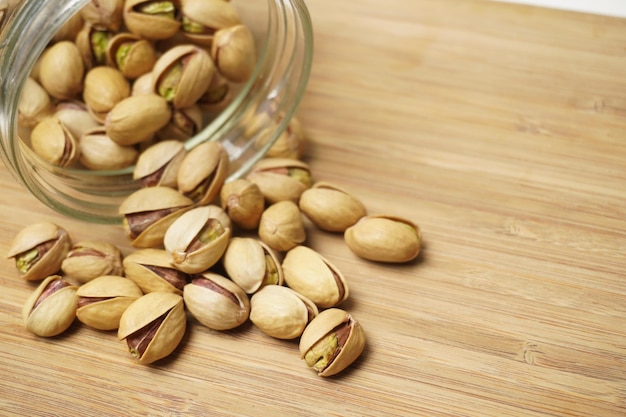 Closeup shot of pistachios on the wooden surface