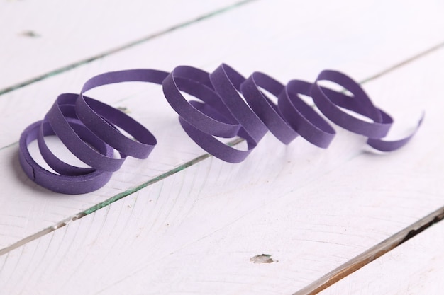 Free Photo closeup shot of a purple party streamer isolated on a white wooden surface