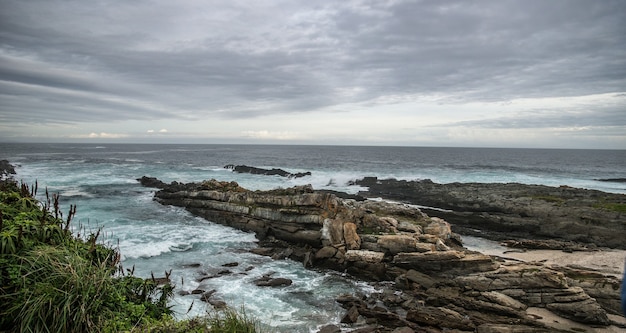 Closeup shot of the rocks on a beach under a sky full of clouds