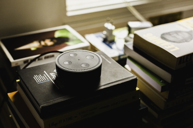 Free photo closeup shot of a round black small audio control device on books indoors