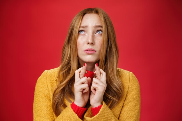 Closeup shot of sad and nervous hopeful upset redhead female looking up faithfully frowning concerne...