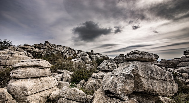 Free photo closeup shot of several grey rocks on top of each other under a cloudy sky