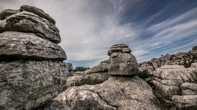 Free photo closeup shot of several grey rocks on top of each other under a cloudy sky