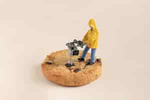 Free photo closeup shot of a small construction worker working on a chocolate cookie