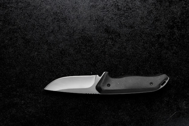 Free Photo closeup shot of a small sharp knife with a black handle on a black background