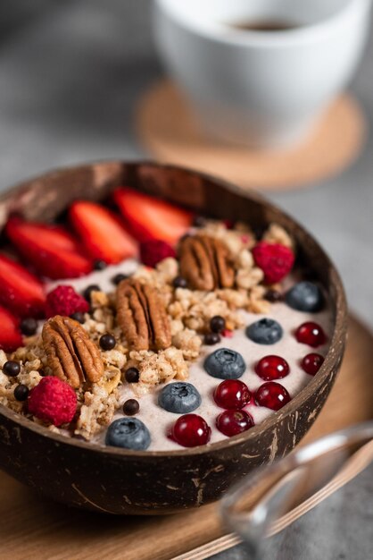 Closeup shot of a smoothie bowl in a wooden bowl in a cafe