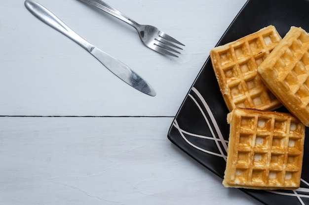 Free photo closeup shot of square waffles on a wooden table background