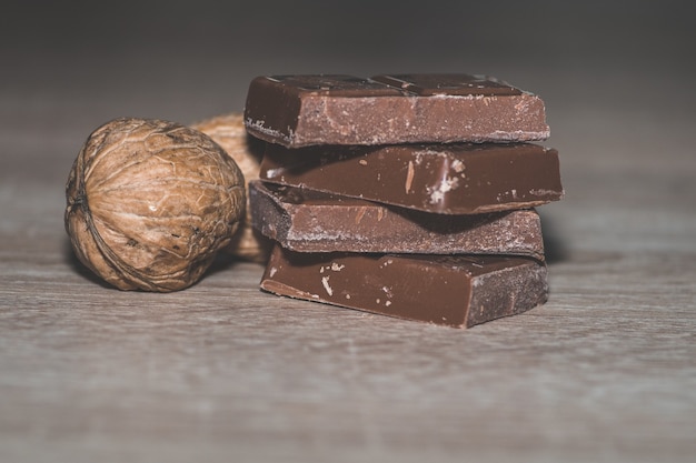 Free Photo closeup shot of a stack of chocolates with shelled walnuts