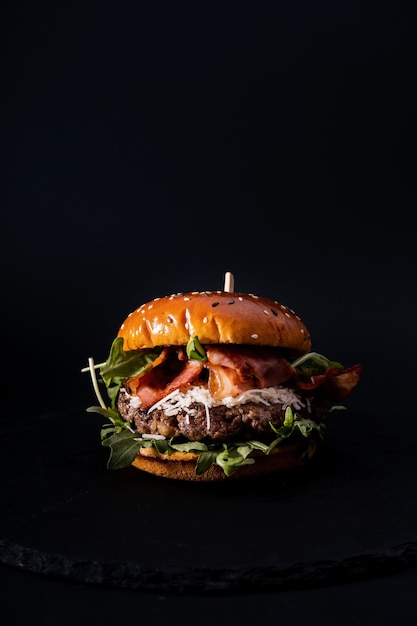 Closeup shot of a tasty looking burger isolated on a black surface