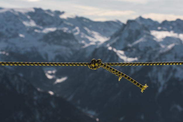 Free photo closeup shot of a twisted rope in front of the mountains covered in snow