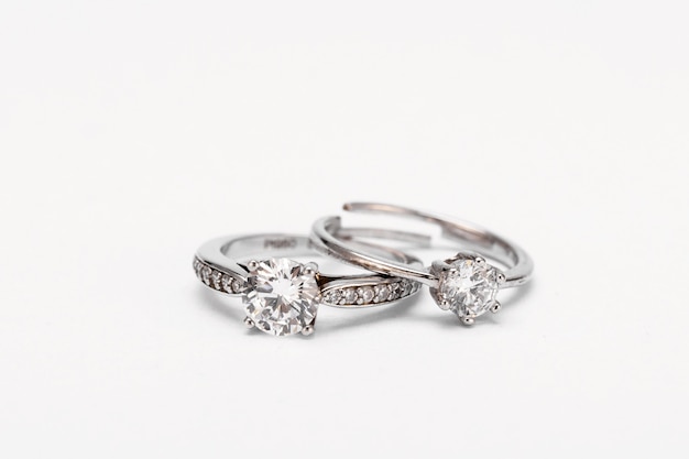 Free photo closeup shot of two diamond rings on a white surface