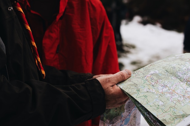 Free Photo closeup shot of two people holding and reading a map in a snowy area