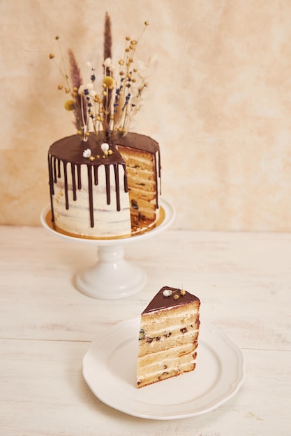 Free Photo closeup shot of a vanilla cake with chocolate drip and flowers on top