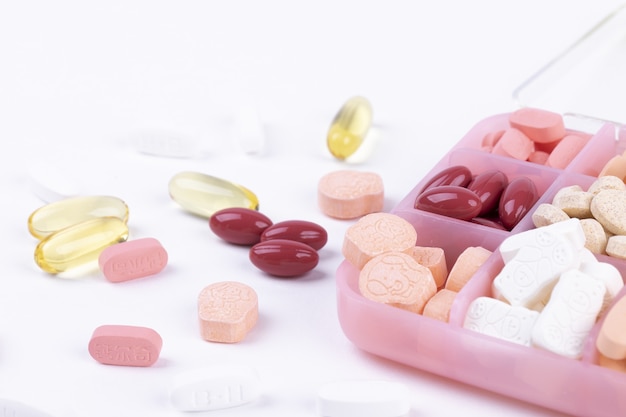 Closeup shot of various pharmaceuticals in a container for medications on a white background