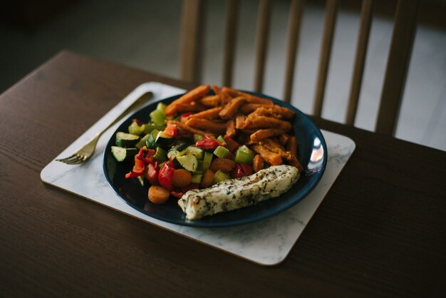 Closeup shot of a vegetable salad and potatoes cut into fine juliennes on the wooden table