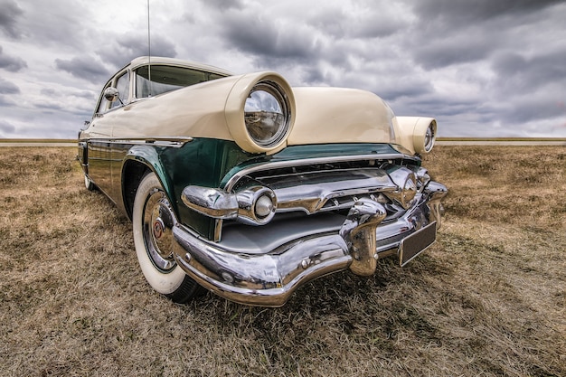 Free photo closeup shot of a vehicle on a dry field under a cloudy sky