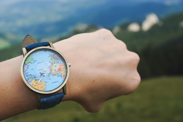 Free photo closeup shot of a watch tied to a hand with world map on it