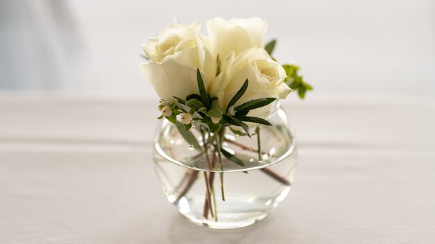 Closeup shot of white rose bouquet in the glass bowl isolated