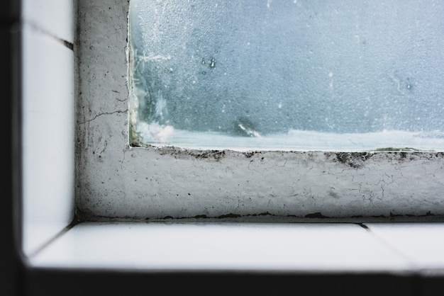 Free photo closeup shot of a wild windowsill with an old window and the glass covered in frosting