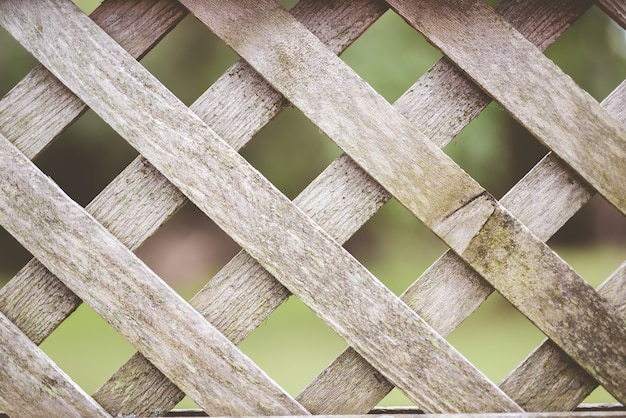 Free Photo closeup shot of a wooden criss-cross fence with a blurred