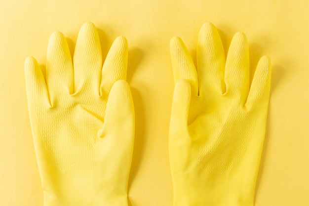 Free Photo closeup shot of yellow plastic gloves on a yellow surface