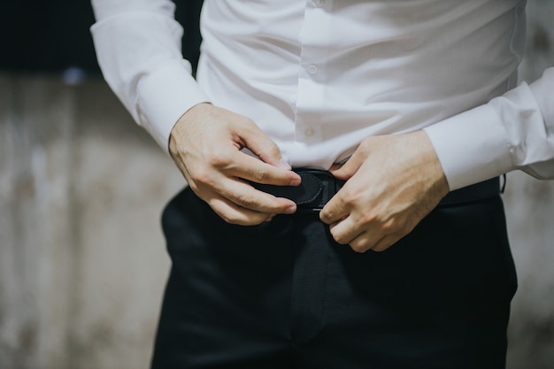 Free Photo closeup shot of a young and handsome groom getting dressed.