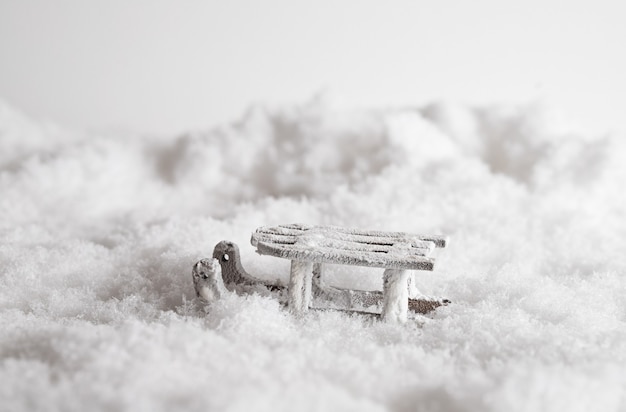 Free photo closeup of a sleigh in the snow, christmas decorative toy in the white background