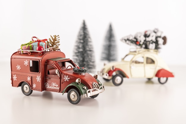 Free photo closeup of small toy cars on the table with small christmas trees in the background