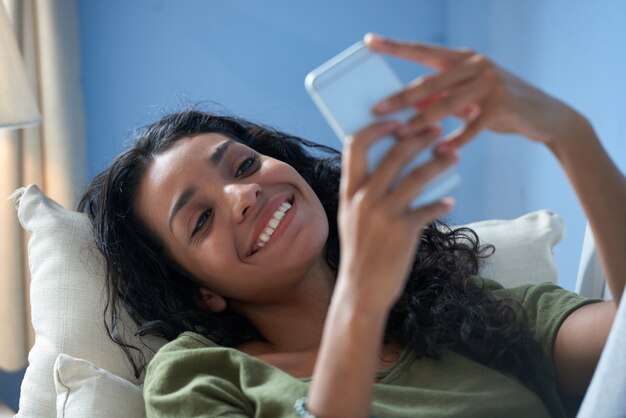 Closeup of a smiling girl texting a message to her boyfriend