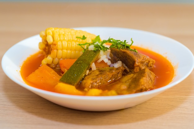 Closeup of soup in a white bowl on a wooden surface